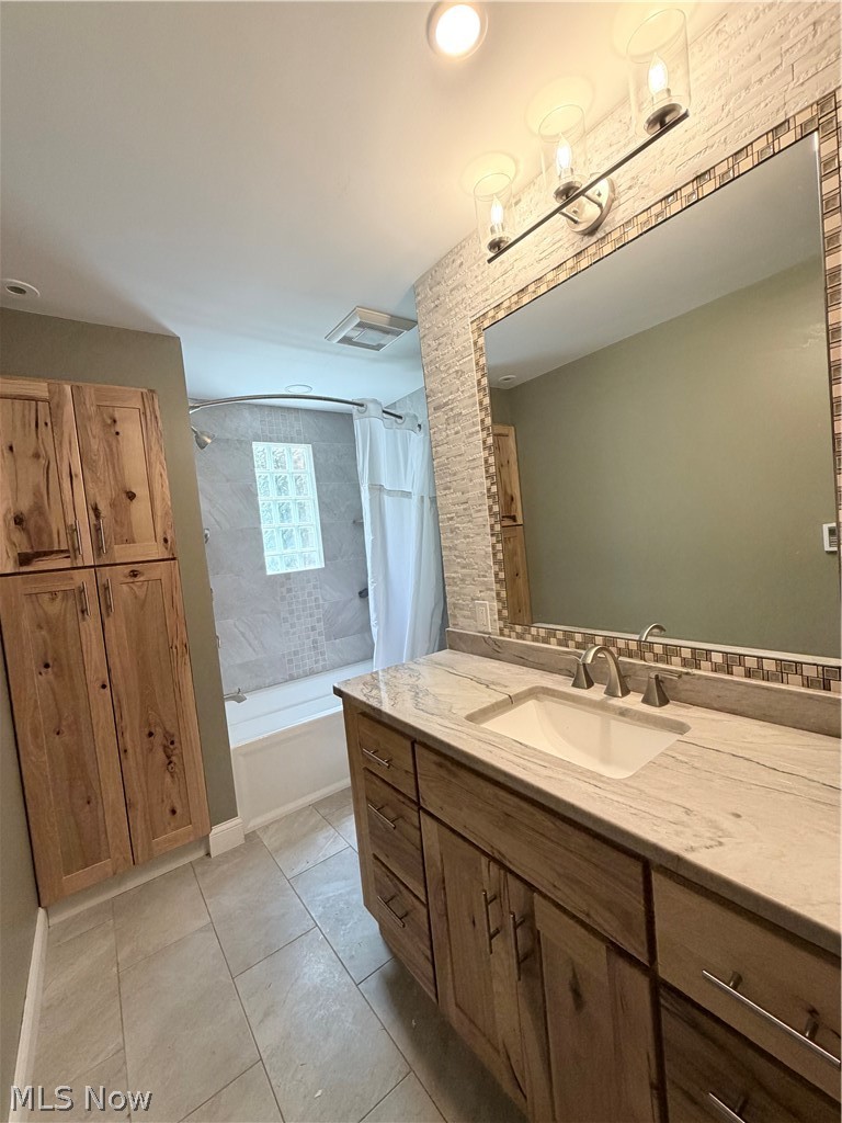 12590 Rockhaven Road Chesterland, OH 44026 - Photo 11 of 25 Bathroom featuring a wide vanity with wood-finish cabinetry, a single basin sink, and a light-toned countertop