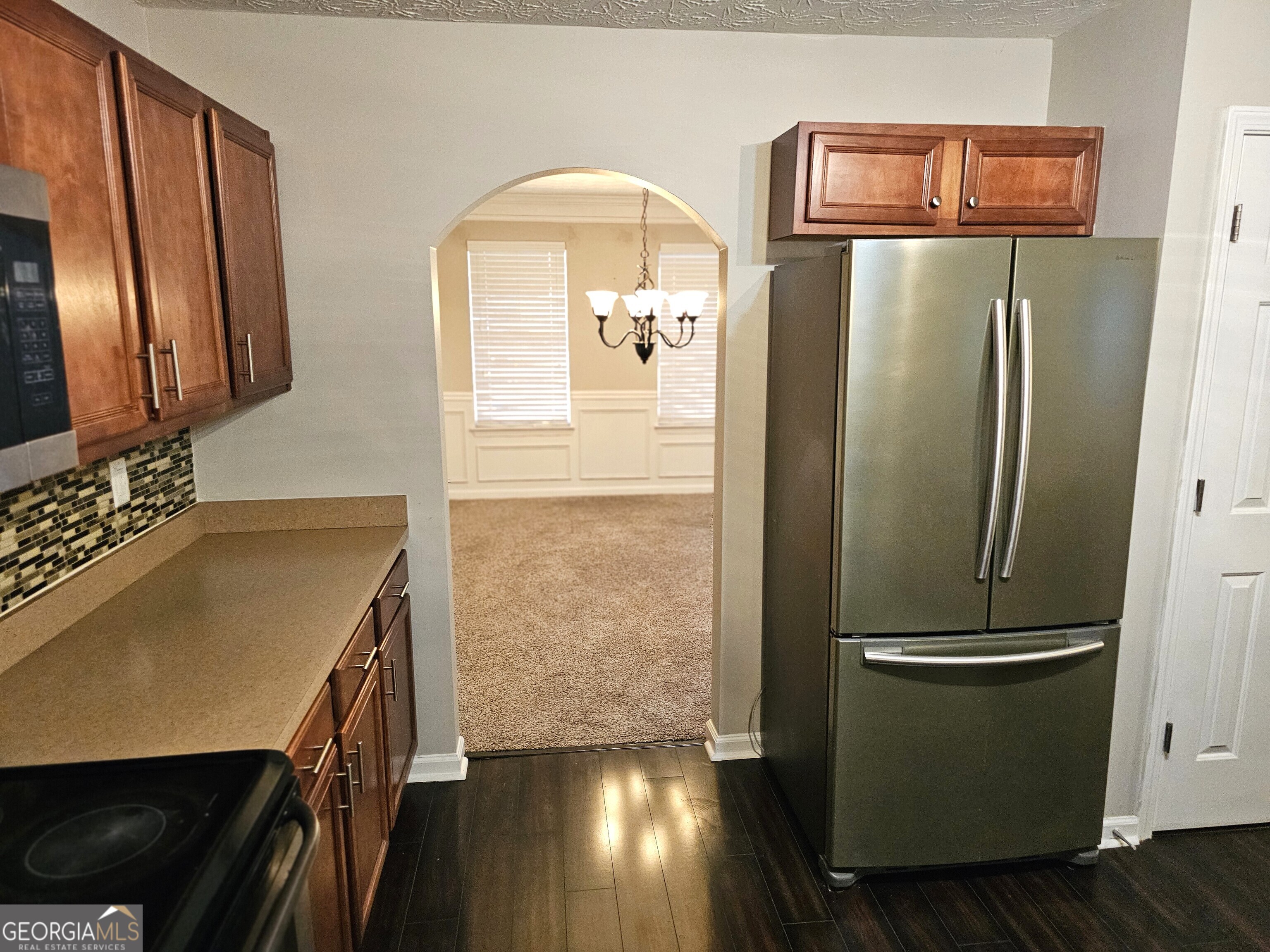 11223 Genova Terrace Hampton, GA 30228 - Photo 11 of 26 a kitchen with a refrigerator and wooden floor