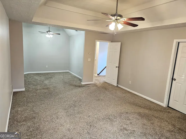 a view of a hallway with wooden floor and a bathroom