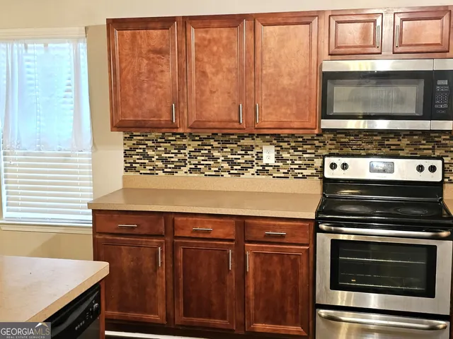 a kitchen with a refrigerator and wooden floor