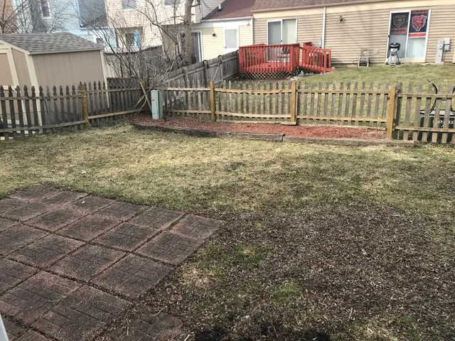 a view of a house with a small yard and wooden fence