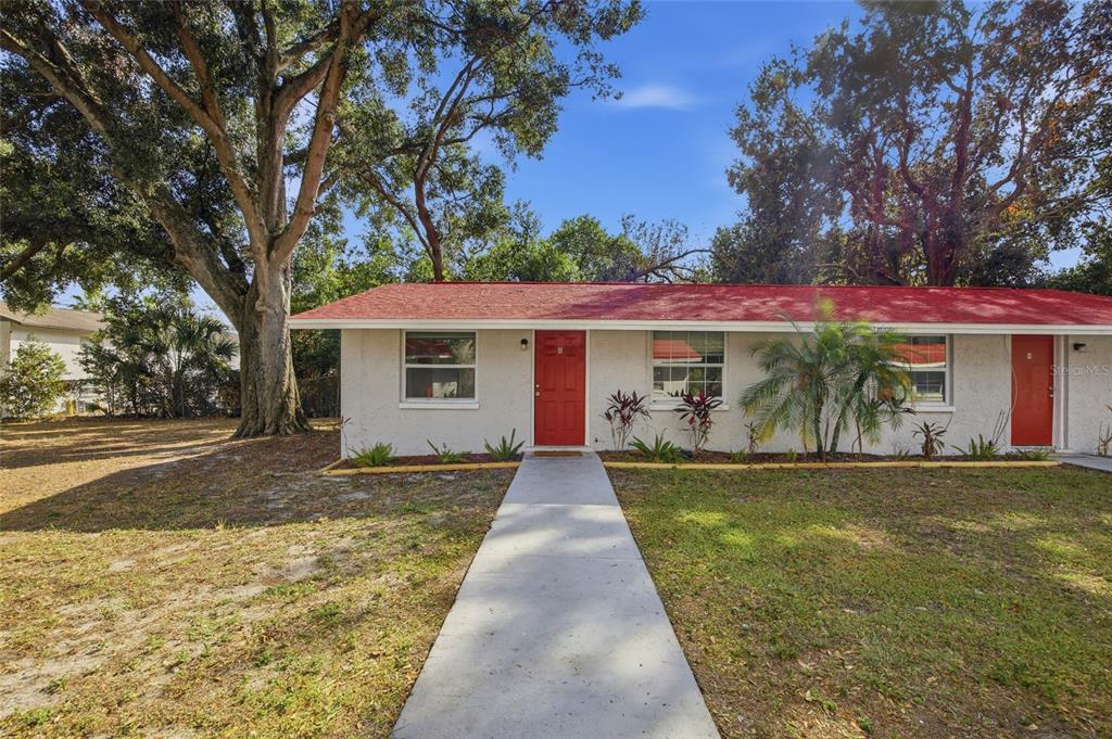 11733 North 12th Street, Unit G Tampa, FL 33612 - Photo 2 of 25 a front view of a house with a yard and garage
