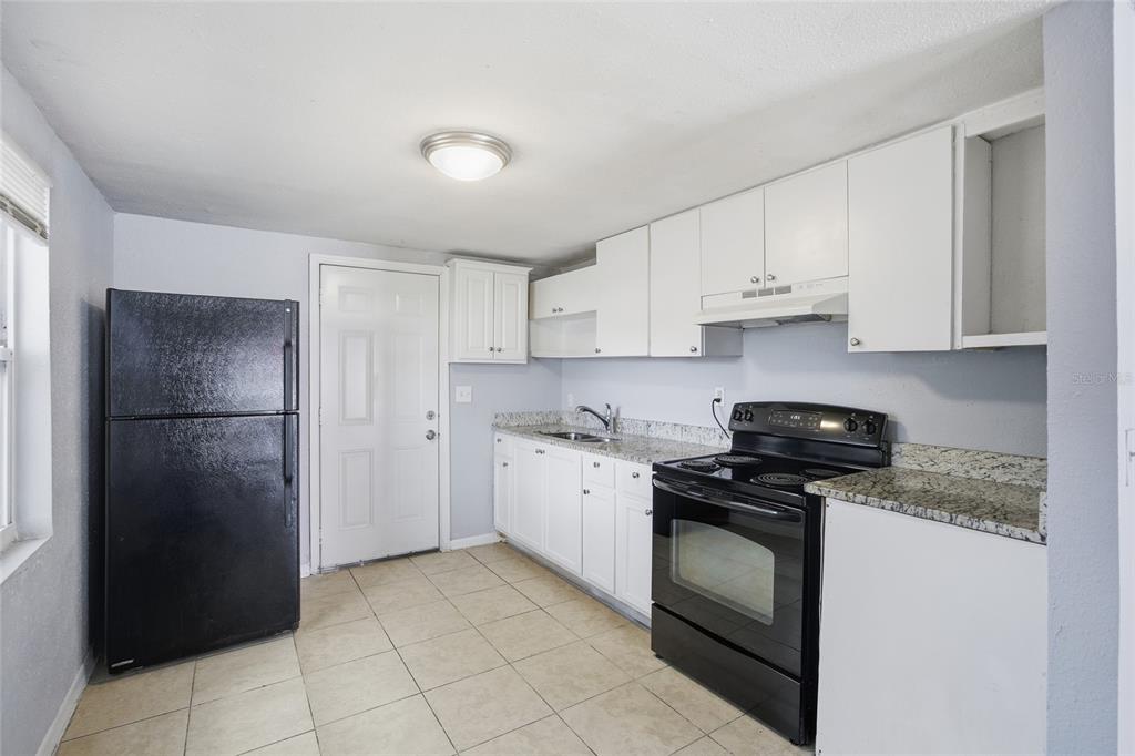 11733 North 12th Street, Unit G Tampa, FL 33612 - Photo 6 of 25 a kitchen with a stove sink and refrigerator
