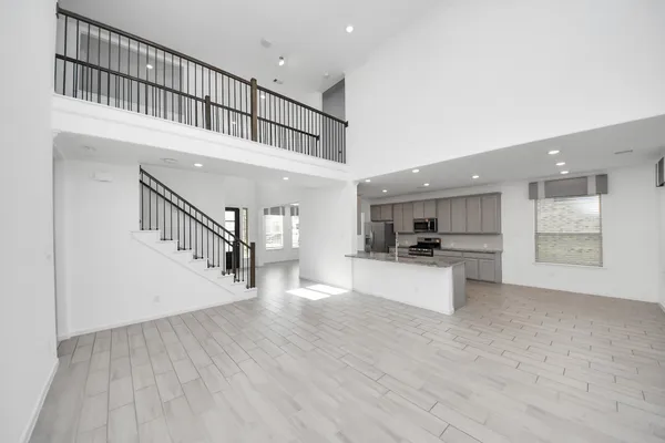 a view of kitchen with microwave oven a stove and white cabinets with wooden floor