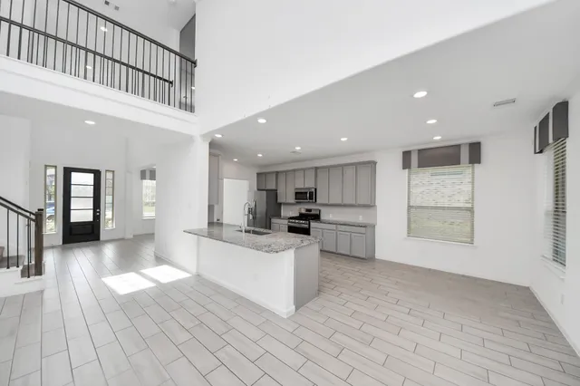 a view of a kitchen with kitchen island white cabinets and refrigerator
