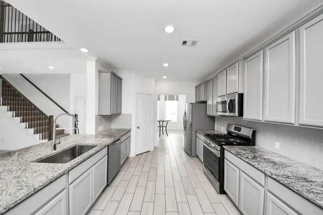 a kitchen with stainless steel appliances granite countertop a sink stove and refrigerator