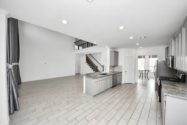 a kitchen with stainless steel appliances granite countertop a refrigerator and a stove
