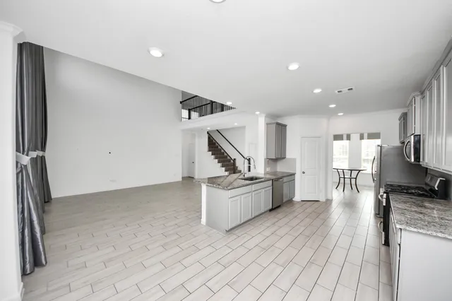 a kitchen with stainless steel appliances granite countertop a refrigerator and a stove
