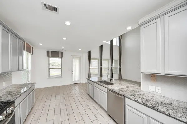 a large kitchen with granite countertop a lot of counter space and a sink