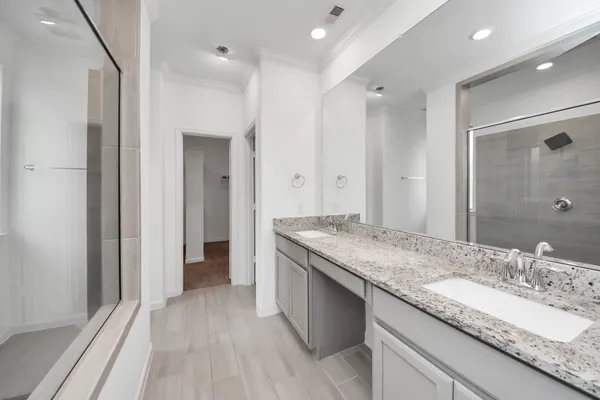 a bathroom with a granite countertop sink a mirror and a shower