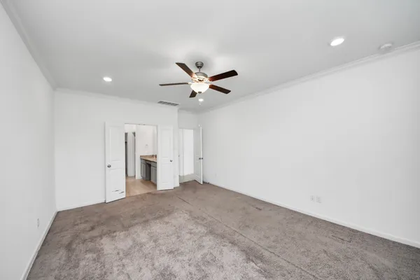 an empty room with closet and ceiling fan