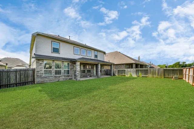 a view of a big house with a big yard and large trees
