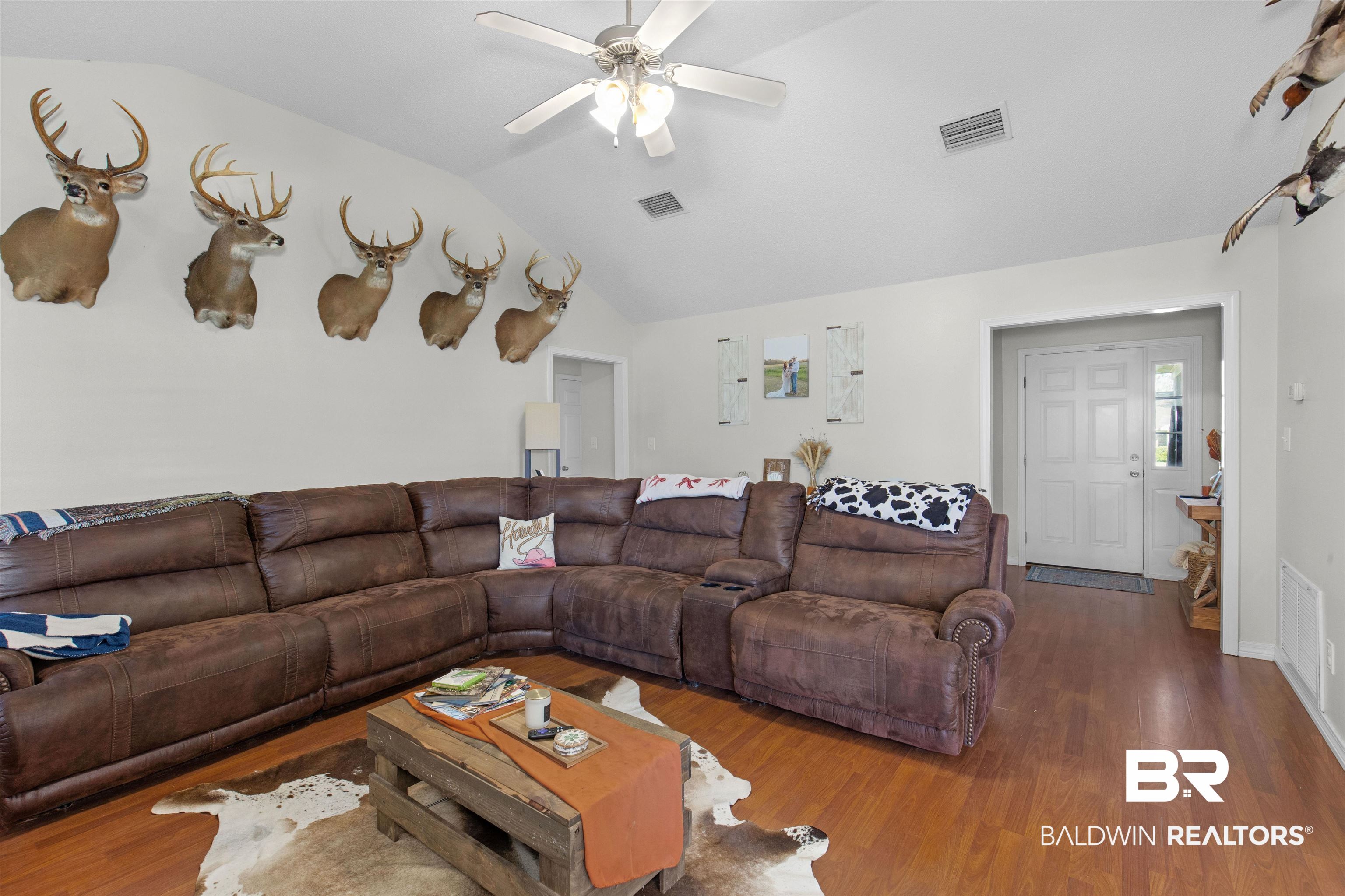 4950 Clealand Court Mobile, AL 36695 - Photo 4 of 20 Living area featuring lofted ceiling, wood finished floors, and visible vents