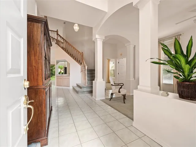 a view of a hallway with windows and chandelier