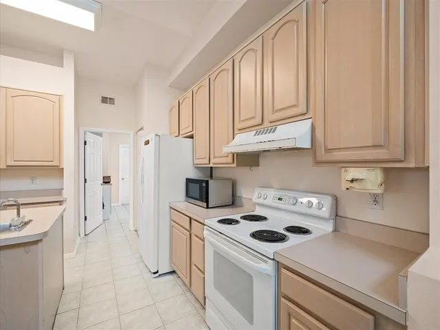 a spacious bedroom with a bed and a chandelier