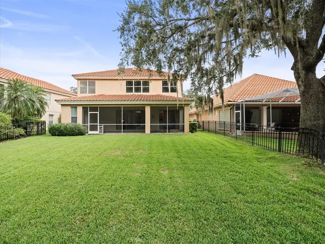 a view of a big yard with plants and large trees