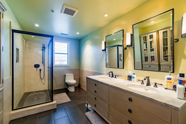 a bathroom with a double vanity sink mirror and toilet