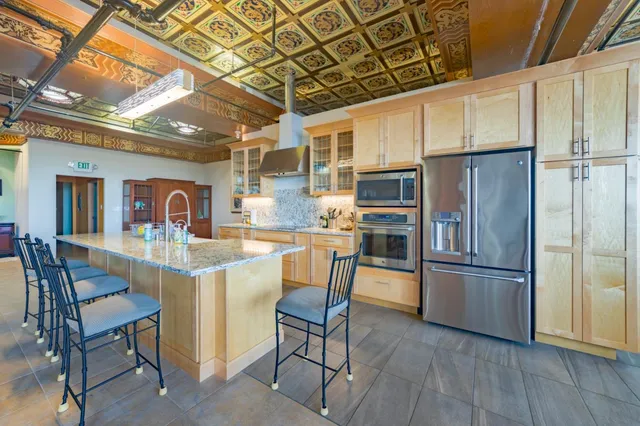 a kitchen with stainless steel appliances granite countertop a refrigerator and a stove top oven