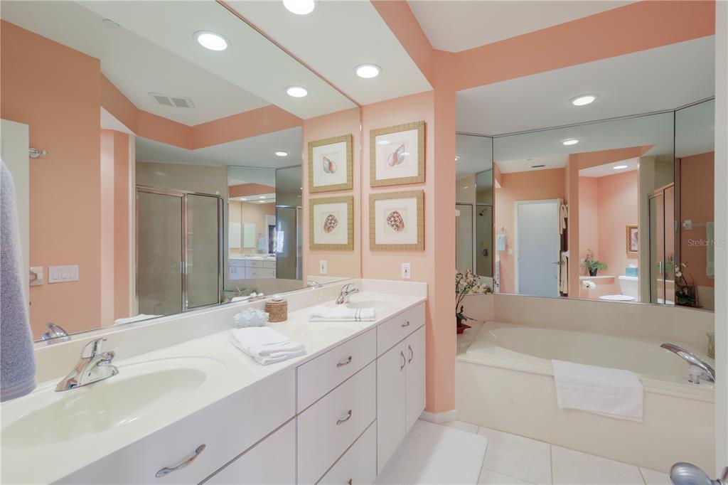 760 Seaboard Line Lane Boca Grande, FL 33921 - Photo 19 of 71 a spacious bathroom with a double vanity sink a large mirror and a bathtub