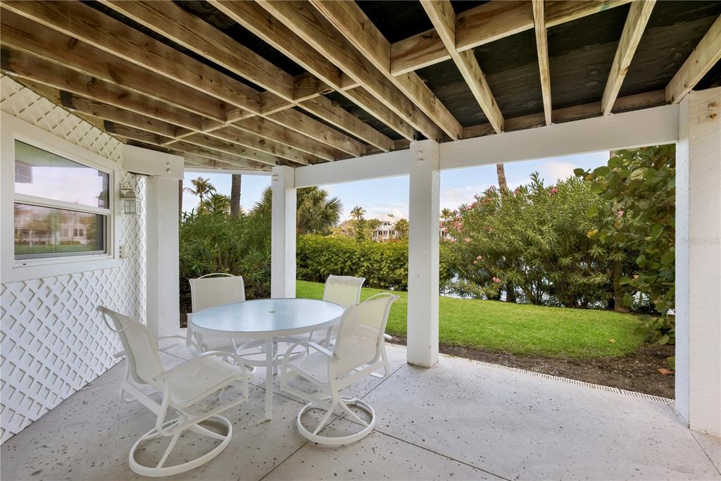 760 Seaboard Line Lane Boca Grande, FL 33921 - Photo 22 of 71 a patio with a table and chairs and potted plants