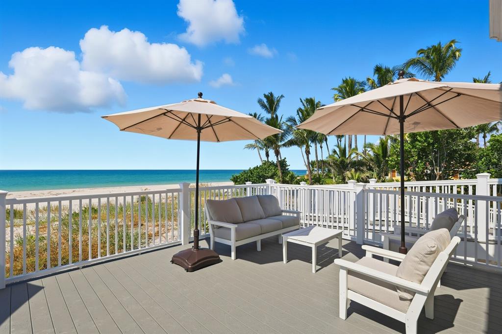 760 Seaboard Line Lane Boca Grande, FL 33921 - Photo 32 of 71 a view of a patio with a table and chairs under an umbrella with wooden fence