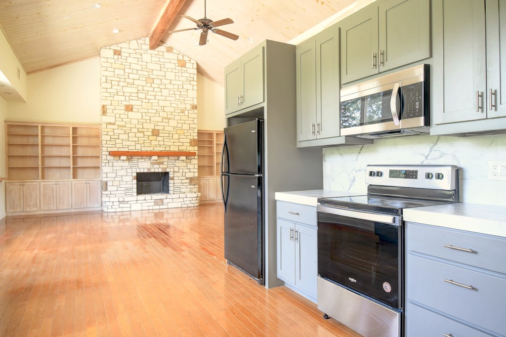 155 B Nimitz Road Kerrville, TX 78028 - Photo 13 of 30 a kitchen with stainless steel appliances granite countertop a stove a refrigerator and a microwave