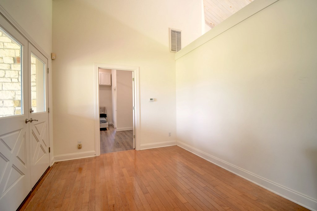 155 B Nimitz Road Kerrville, TX 78028 - Photo 16 of 30 an empty room with wooden floor and windows