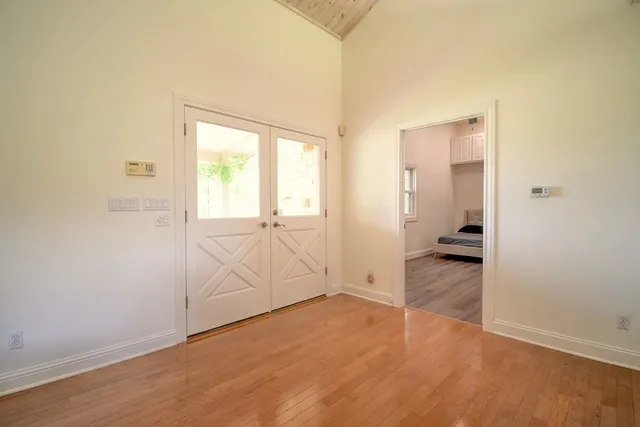an empty room with wooden floor and windows