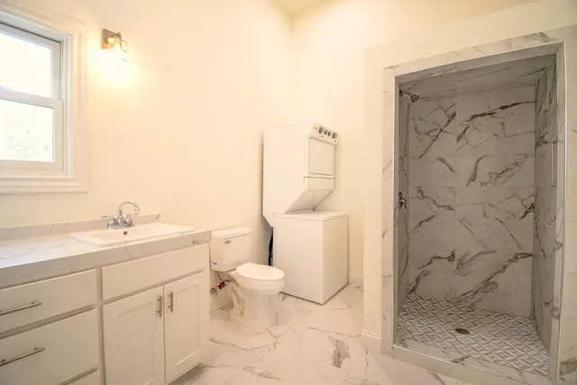 a bathroom with a sink a toilet and shower