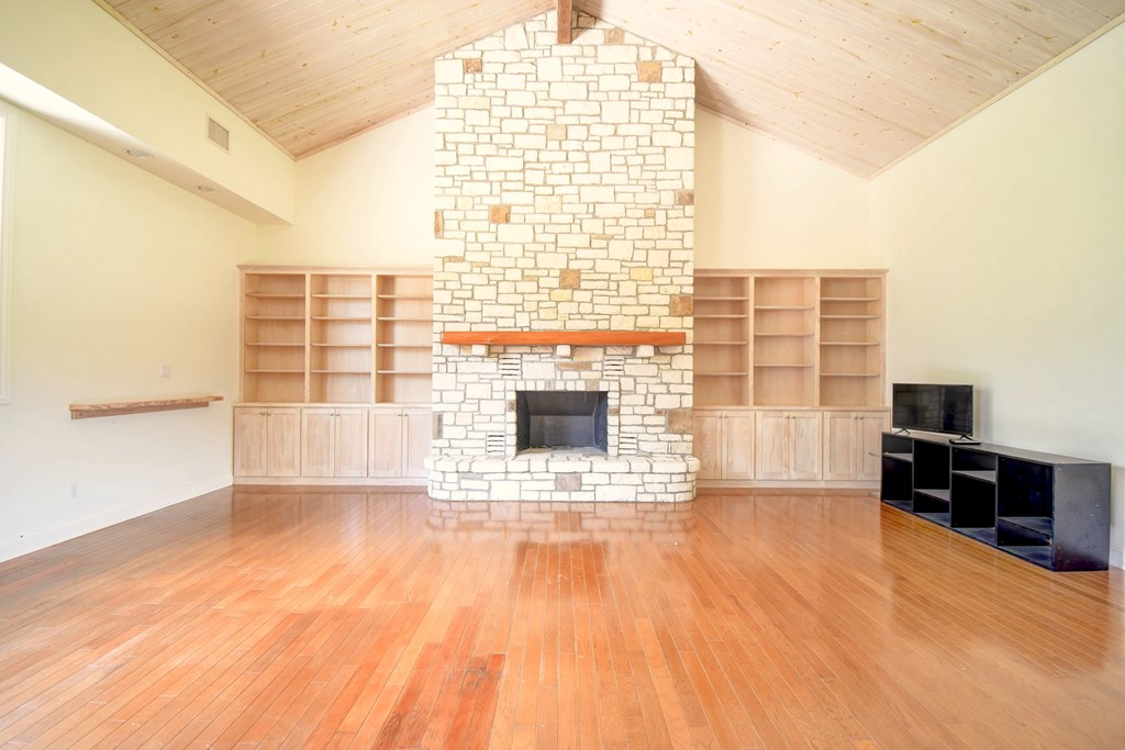 155 B Nimitz Road Kerrville, TX 78028 - Photo 7 of 30 a view of an empty room with a window and wooden floor