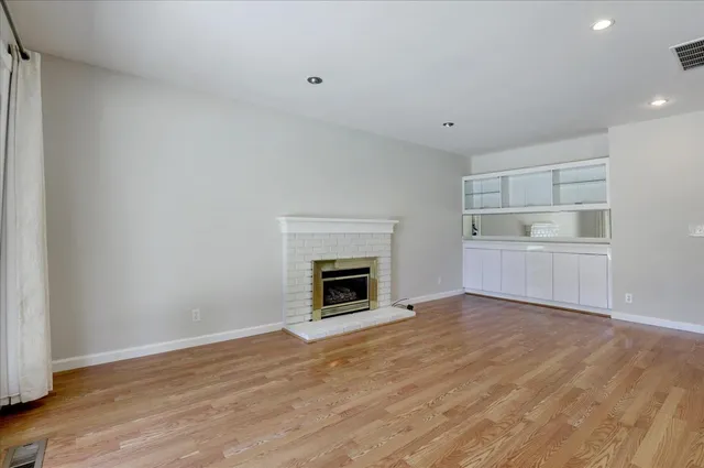 a view of a room with wooden floor and fireplace