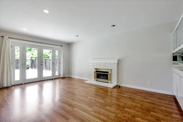 a view of empty room with wooden floor and fireplace