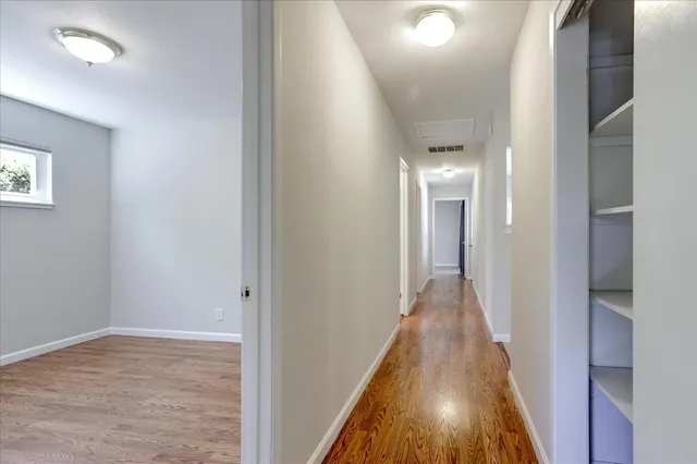 a view of a hallway with wooden floor