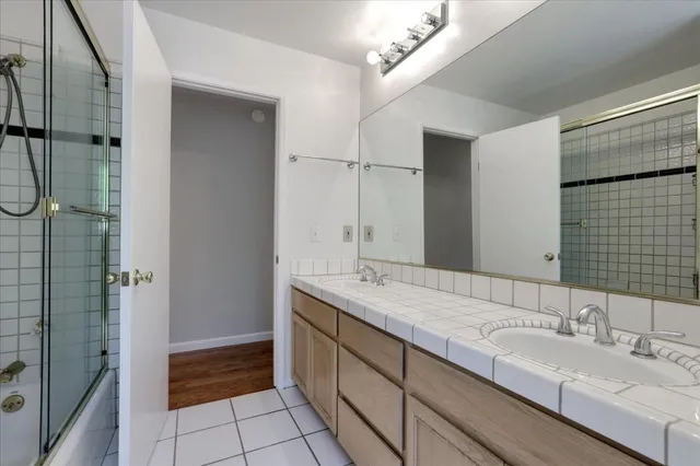 a bathroom with a granite countertop sink mirror and shower