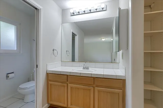 a bathroom with a toilet sink and mirror