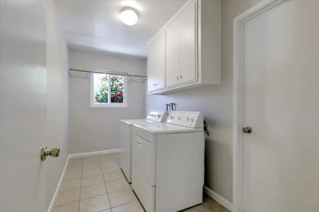a utility room with cabinets washer and dryer