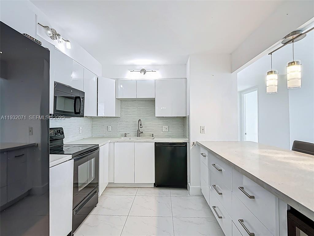2801 Northeast 183rd Street, Unit 1504W Aventura, FL 33160 - Photo 21 of 57 a kitchen with a sink stove top oven and microwave