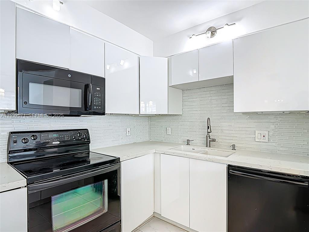 2801 Northeast 183rd Street, Unit 1504W Aventura, FL 33160 - Photo 22 of 57 a kitchen with a sink stove and microwave