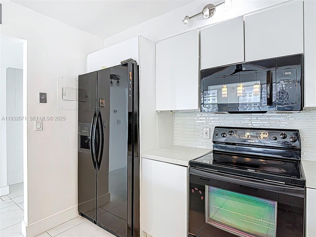 2801 Northeast 183rd Street, Unit 1504W Aventura, FL 33160 - Photo 23 of 57 a kitchen with stainless steel appliances granite countertop a refrigerator and a stove