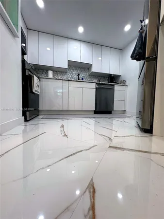 a kitchen with stainless steel appliances granite countertop a refrigerator sink and stove