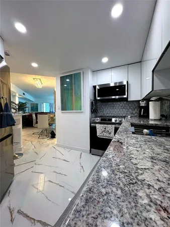 a kitchen with stainless steel appliances kitchen island granite countertop a sink stove and cabinets