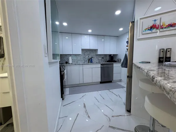 a large kitchen with stainless steel appliances kitchen island granite countertop a large counter top a stove a sink a refrigerator and a granite counter tops