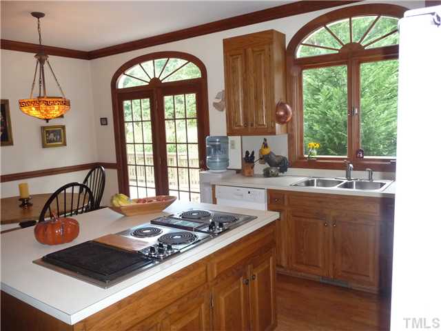 9916 Baileywick Road Raleigh, NC 27613 - Photo 11 of 25 a kitchen with a stove a sink a window and dining table