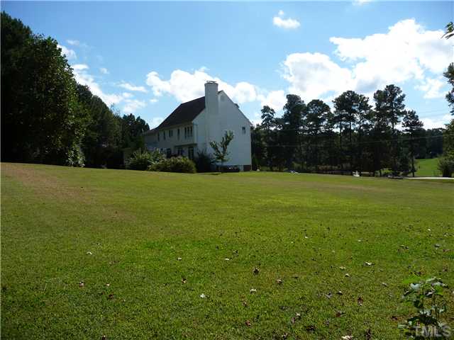 9916 Baileywick Road Raleigh, NC 27613 - Photo 2 of 25 a view of a green field with wooden fence