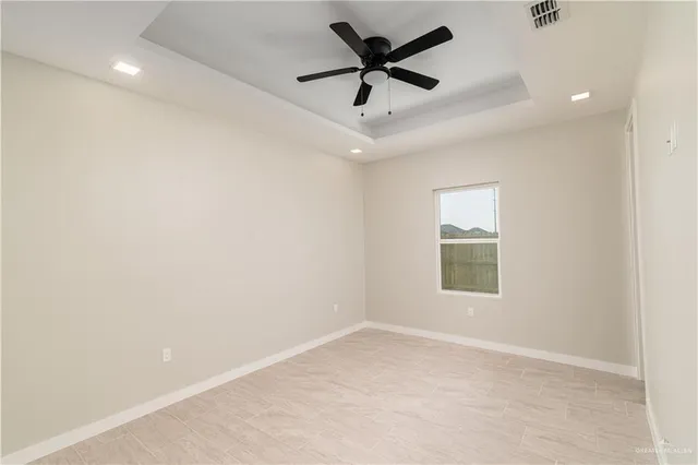 an empty room with a window and a ceiling fan