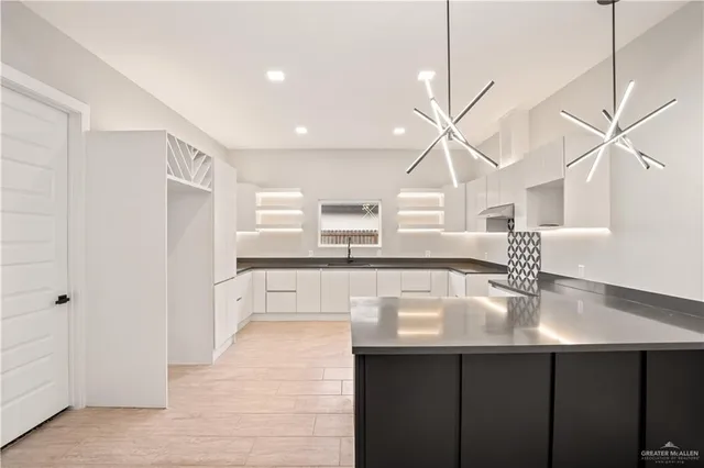 a kitchen with kitchen island a sink stainless steel appliances and cabinets