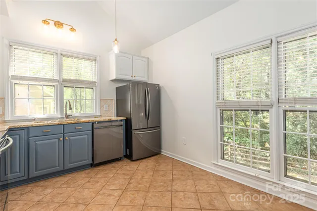 a large kitchen with a window appliances and cabinets