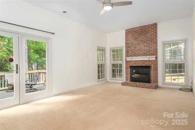 a view of an empty room with a fireplace and a window