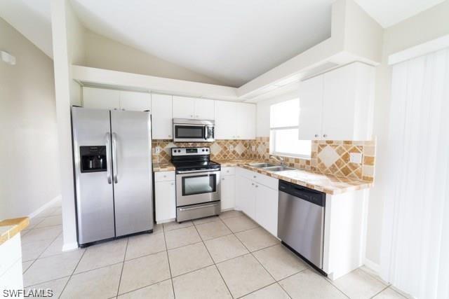 18513 Olive Road Fort Myers, FL 33967 - Photo 2 of 15 a kitchen with white cabinets and stainless steel appliances
