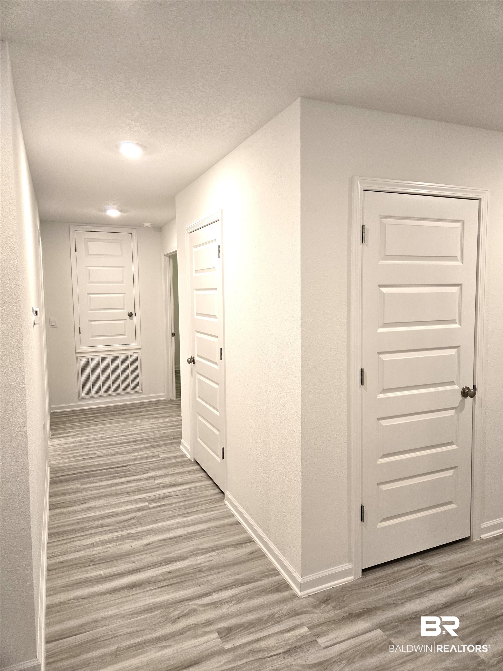 24385 Ringneck Loop Elberta, AL 36530 - Photo 19 of 33 Hallway featuring light hardwood / wood-style flooring and a textured ceiling